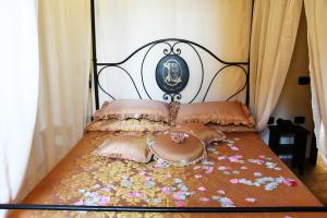 a bed with a black and white headboard and pillows at Grand Relais Laurenti in Gualdo Cattaneo