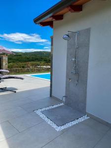 a shower on the side of a house with a pool at Villa Santoma Hill in Koper