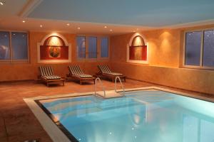 a swimming pool in a hotel room with two chairs at Bellevue Rheinhotel in Boppard