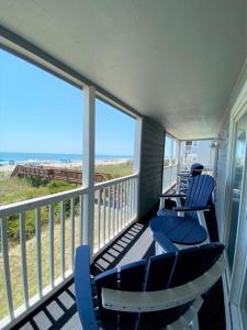 two blue chairs on a balcony with a view of the beach at Cape Coddages I 103 Condo in Myrtle Beach