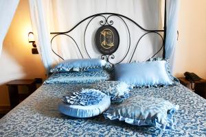 a bedroom with two beds with blue pillows at Grand Relais Laurenti in Gualdo Cattaneo