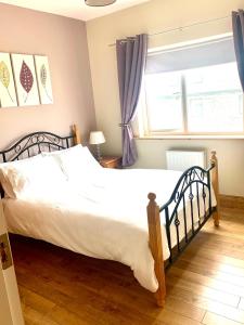 1 dormitorio con cama y ventana en Wild Atlantic Way Cottage, en Achill