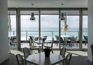 a room with tables and chairs and a view of the ocean at Arribas Sintra Hotel in Sintra