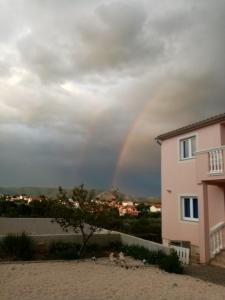 Ein Regenbogen über einem Haus in der Unterkunft Apartments T&C in Drage
