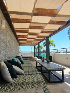 a patio with a table and pillows on a couch at Azura Boutique Hotel in Tulum