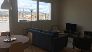 ein Wohnzimmer mit einem Sofa, einem Tisch und einem TV in der Unterkunft ATICO LOGROÑO CENTRO con garaje incluido 2 in Logroño