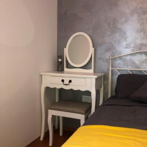 a table with a mirror and a chair next to a bed at Villa Santoma Hill in Koper