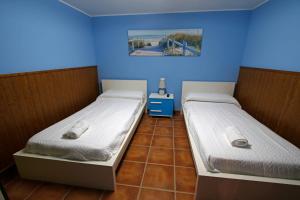 里瓦德塞利亞的住宿－La casina de ribadesella 5 personas，蓝色墙壁客房中的两张单人床