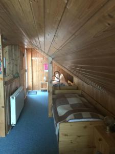 um quarto com uma cama num quarto de madeira em Ferienwohnung Gürth em Kleinhennersdorf