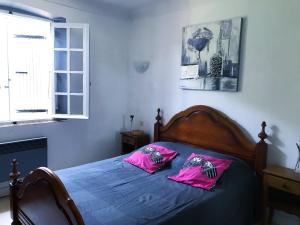 Un dormitorio con una cama con almohadas rosas. en Chambre Privée dans Villa Provençale, en Saint-Tropez
