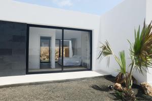 a house with a glass window with a bed in it at Duna Colorada in La Oliva
