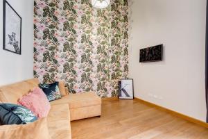 uma sala de estar com um sofá e um papel de parede floral em Klioos Apartment em Roma