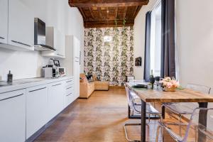 uma cozinha com armários brancos e uma mesa de madeira em Klioos Apartment em Roma
