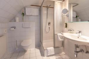 łazienka z prysznicem, toaletą i umywalką w obiekcie Hotel Central w mieście Seefeld in Tirol