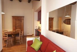 sala de estar con sofá rojo y cocina en San Teodoro Apartment en Roma