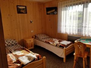 a bedroom with two beds and a desk and a window at Pokoje U Kantora in Bukowina Tatrzańska