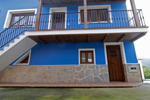 Cette maison bleue dispose d'un balcon et d'un escalier. dans l'établissement La casina de ribadesella 5 personas, à Ribadesella