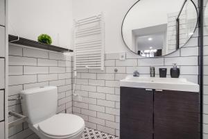 a bathroom with a toilet and a sink and a mirror at K33- Quality Apartments, Best Location, by BQA in Budapest