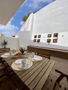 a wooden table with plates of food on a balcony at White Sand Apartments Downtown Albufeira in Albufeira