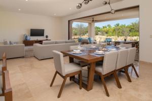 a dining room and living room with a table and chairs at Bohari Palmilla in San José del Cabo