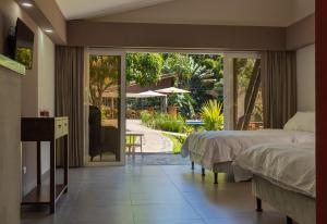 a bedroom with two beds and a view of a patio at Guácima Escondida Hotel Boutique in Guácima