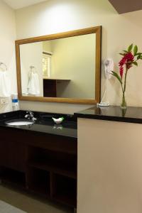 
a bathroom with a mirror and a sink at Guácima Escondida Hotel Boutique in Guácima
