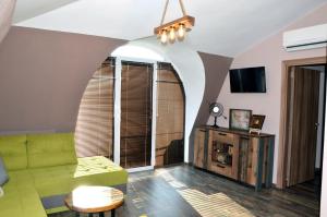 a living room with a green couch and a table at Boutique Villa Amalia in Chernomorets
