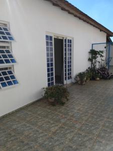 a white house with a door and a patio at Casa da Lili-ESPAÇO INDEPENDENTE E PRIVATIVO in Brotas