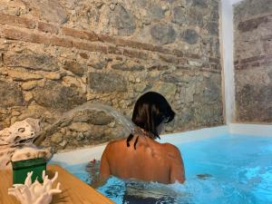 a person in a swimming pool with a dog pouring water at Villino Eleonora in Parghelia