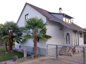 a white house with palm trees in front of it at Ferienhaus Gerda in Friesenheim