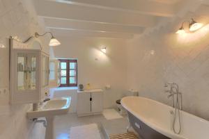 a white bathroom with a tub and a sink at Can Quince de Balafia - Turismo de Interior in Sant Llorenç de Balafia