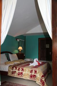 a bedroom with a bed with a stuffed animal on it at Belle Des Iles in La Digue +17 photos