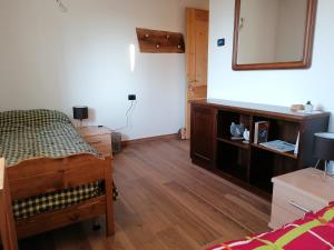 1 dormitorio con cama y espejo en la pared en Az. Agr. Sponga Giancarlo, en Lèvego