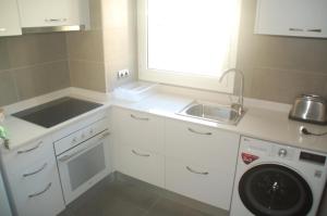 cocina con fregadero y lavadora en Apartament Formentor - Salou, en Salou