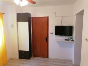 a room with a door and a tv on a wall at Apartment Dinka in Kornić