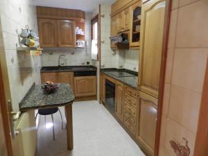 a small kitchen with wooden cabinets and a counter at Vallnord La Massana in La Massana