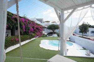 an outdoor patio with a swimming pool and flowers at Hidden Heaven in Mýkonos City