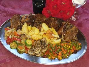 a plate of food with meat and vegetables on a table at Pansion Breza in Plitvička Jezera