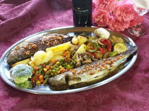 um prato de comida com peixe e legumes numa mesa em Pansion Breza em Plitvicka Jezera