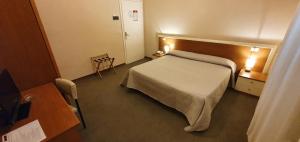 モンテカティーニ・テルメにあるHotel Giovannaのベッドとテーブルが備わるホテルルームです。