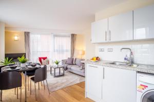 a kitchen and living room with a couch and a table at Stylish City 2 Bed, 2 Bath, FREE PARKING & WiFi in Sheffield