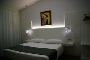 a bedroom with a bed and a painting on the wall at Hotel La Encomienda in Moraleja