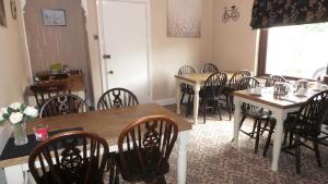 a dining room with tables and chairs and a window at Tynedale Guest House in Penrith