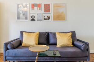un divano blu con cuscini gialli in soggiorno di Mid City Apartments a Cluj-Napoca