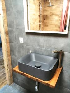 baño con lavabo negro y espejo en Bezpieczna Przystań - Apartamenty en Uherce Mineralne