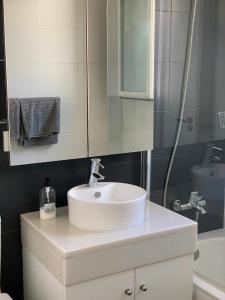 a bathroom with a white sink and a mirror at Ático Romano in Estepona