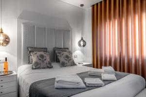 een slaapkamer met een groot bed en 2 handdoeken bij Ilheu 25 Peniche House in Peniche