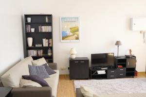 un soggiorno con un divano e una TV di Appartement Cosy et Lumineux idéalement placé a Boulogne-sur-Mer