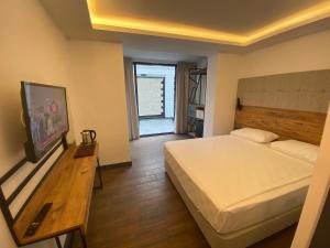 a bedroom with a large bed and a wooden table at MİYAS LUXURY HOTEL in Kemer