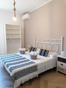 Un dormitorio con una gran cama blanca con almohadas. en Villa per vacanze Isola, en Fanusa